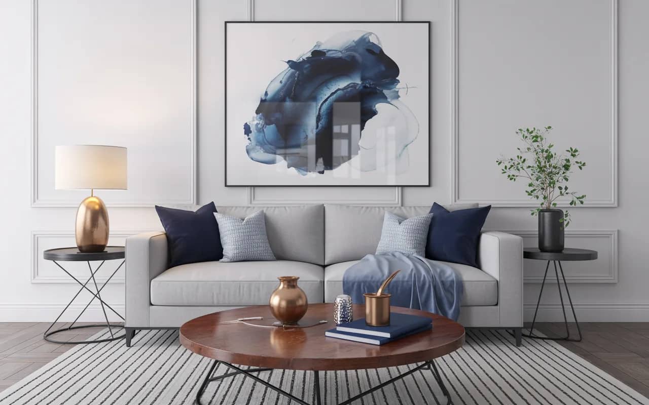 Contemporary living room with white walls, gray sofa, navy accent pillows, wooden coffee table, and metallic decor accents.